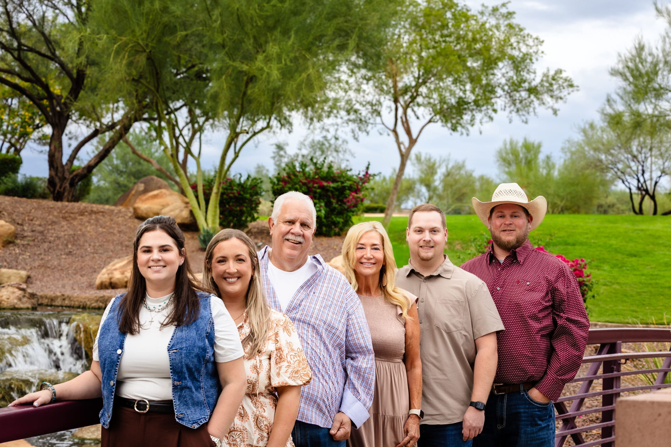 Family group posing on a bridge beside the waterfall at Anthem Community Park