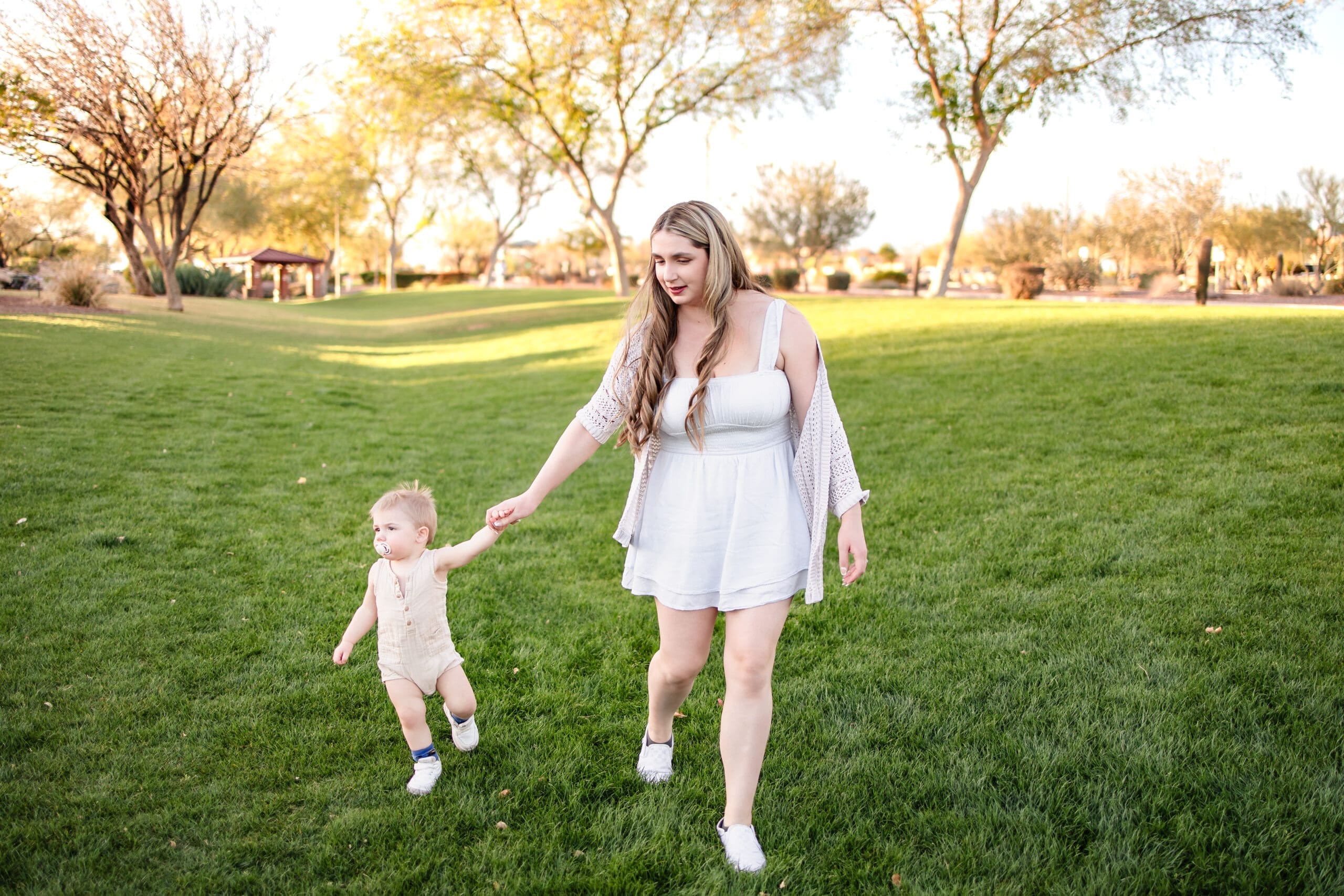 Mother holding hands with her young son during a family photo session at Anthem Community Park in Phoenix.