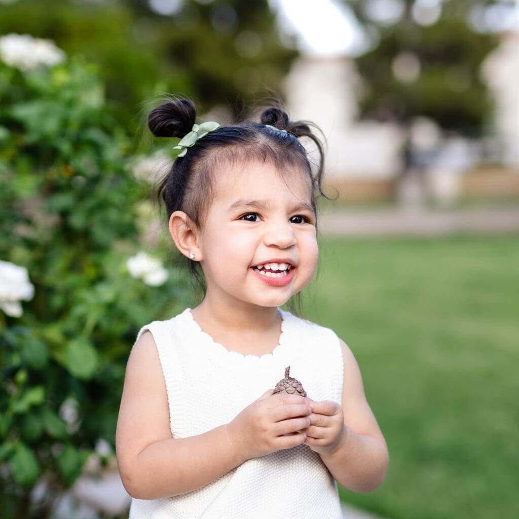 Young girl smiling during a family photo session at Manistee Ranch Park in Glendale, Arizona