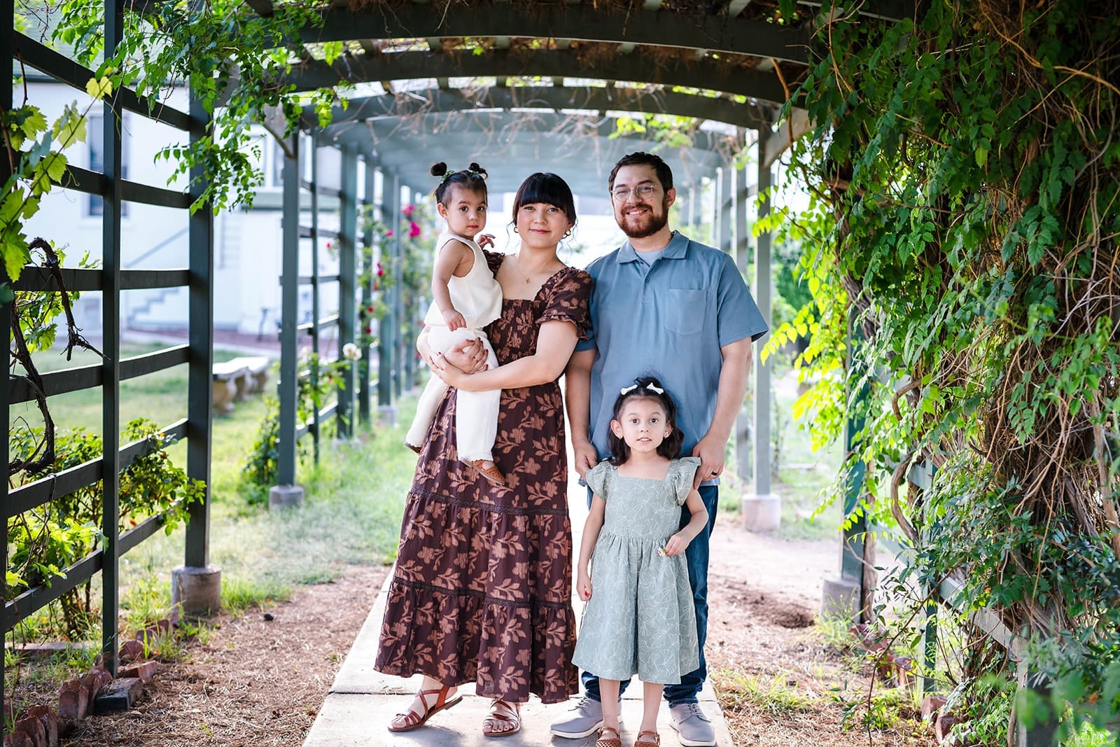 Family of four standing together under the pergola at Manistee Ranch in Glendale.