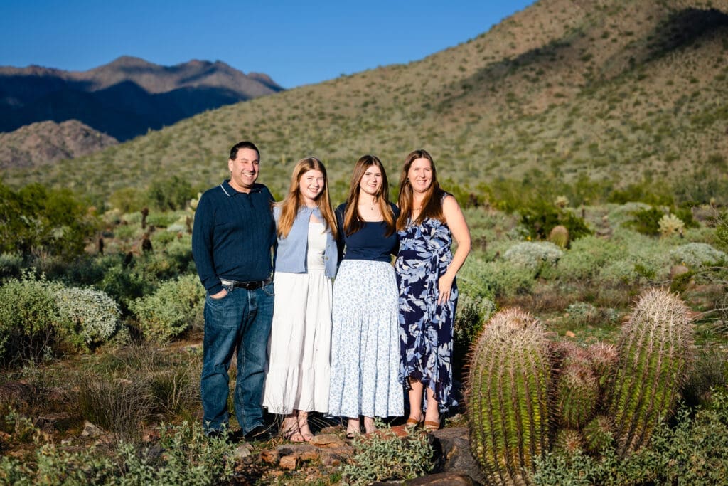 Family of four standing together in the desert near the McDowell Mountains in North Scottsdale.