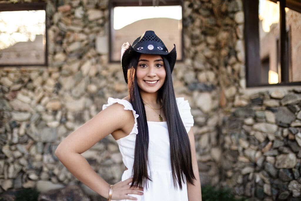 Senior portrait at Scorpion Gulch with a cowboy hat and historic stone walls at South Mountain in Phoenix, Arizona.