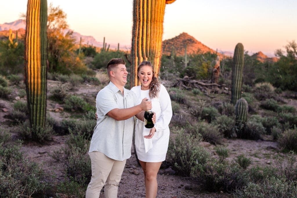 Couple celebrating with champagne during Usery Mountain engagement photos