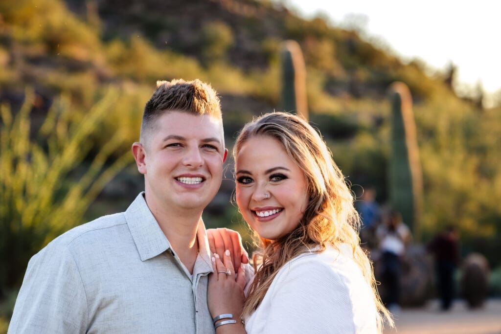 Engaged couple smiling together during a golden hour photo session at Usery Mountain Regional Park near Mesa, Arizona.