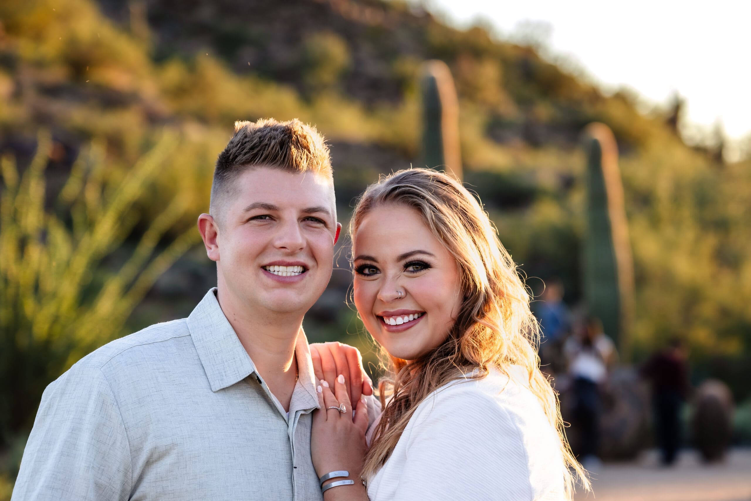 Engaged couple smiling together during a golden hour photo session at Usery Mountain Regional Park near Mesa, Arizona.