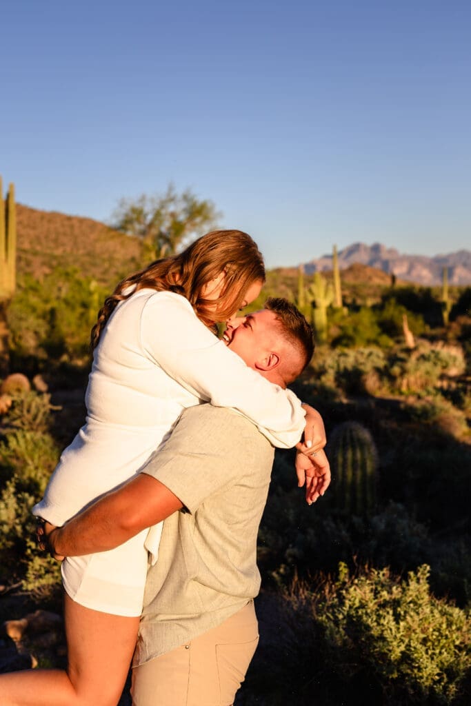 Engaged couple kissing during a sunset photo session at Usery Mountain Regional Park near Mesa, Arizona.