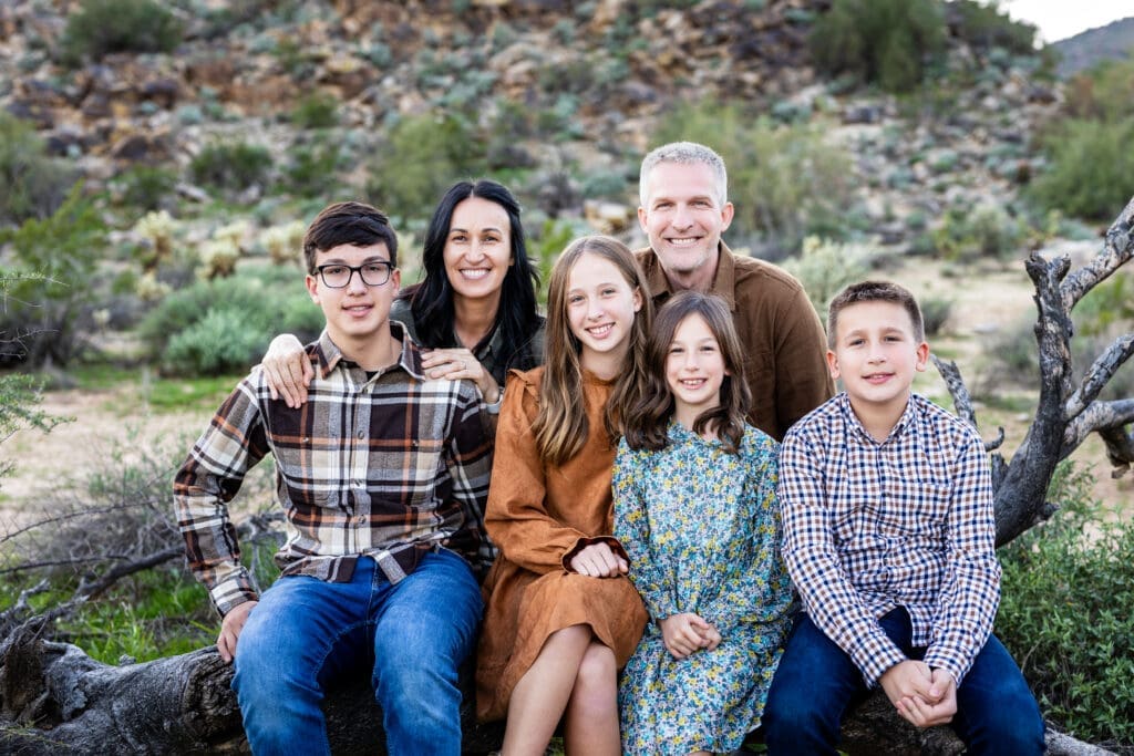 Family of six sitting together for a portrait at White Tank Mountain Regional Park near Phoenix, Arizona.