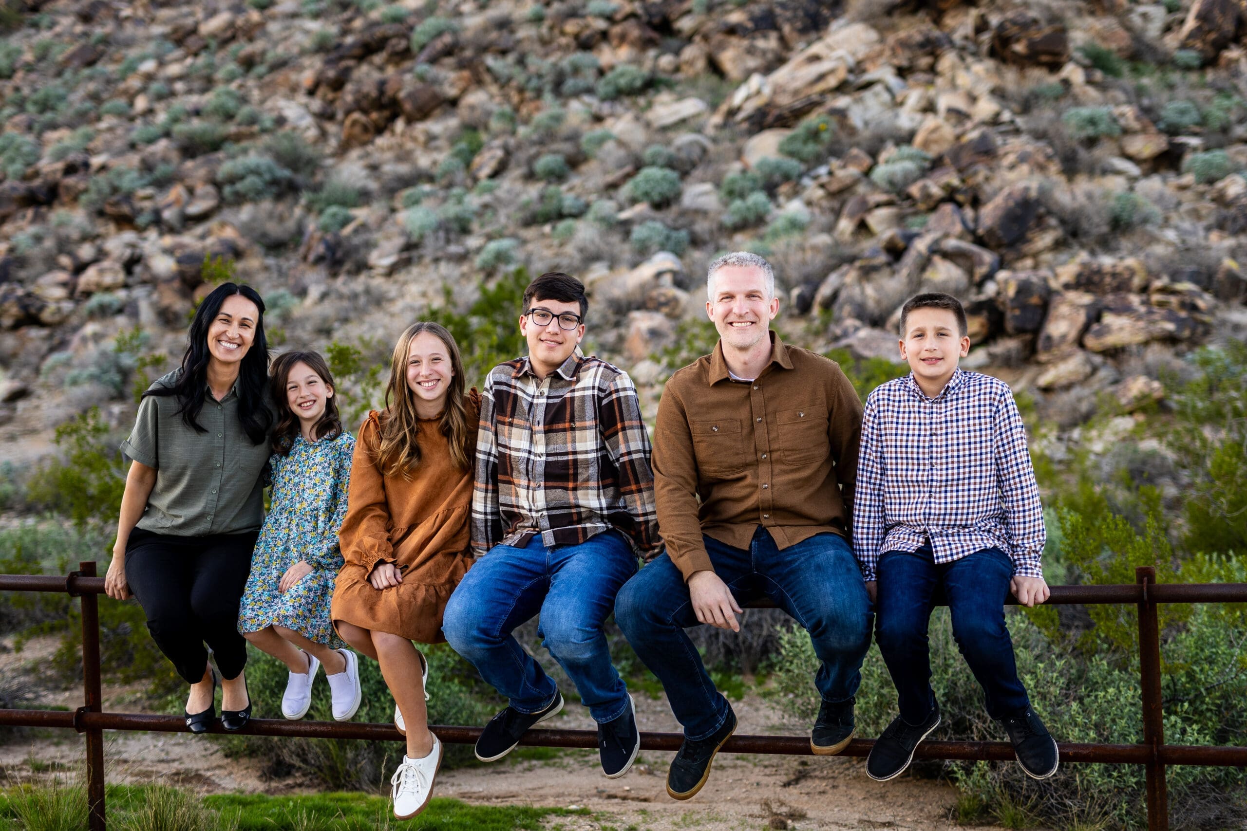 Family of six sitting together during a desert photo session at White Tank Mountain Regional Park near Phoenix, Arizona.