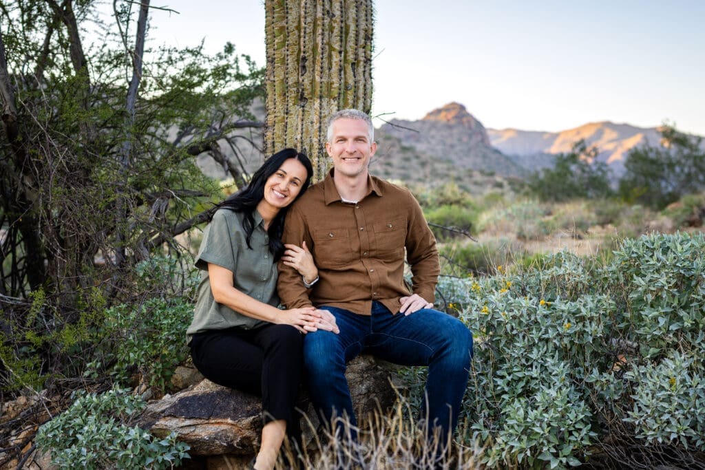 Couple sitting together in the desert during a White Tank Mountain Regional Park photo session near Phoenix, Arizona.