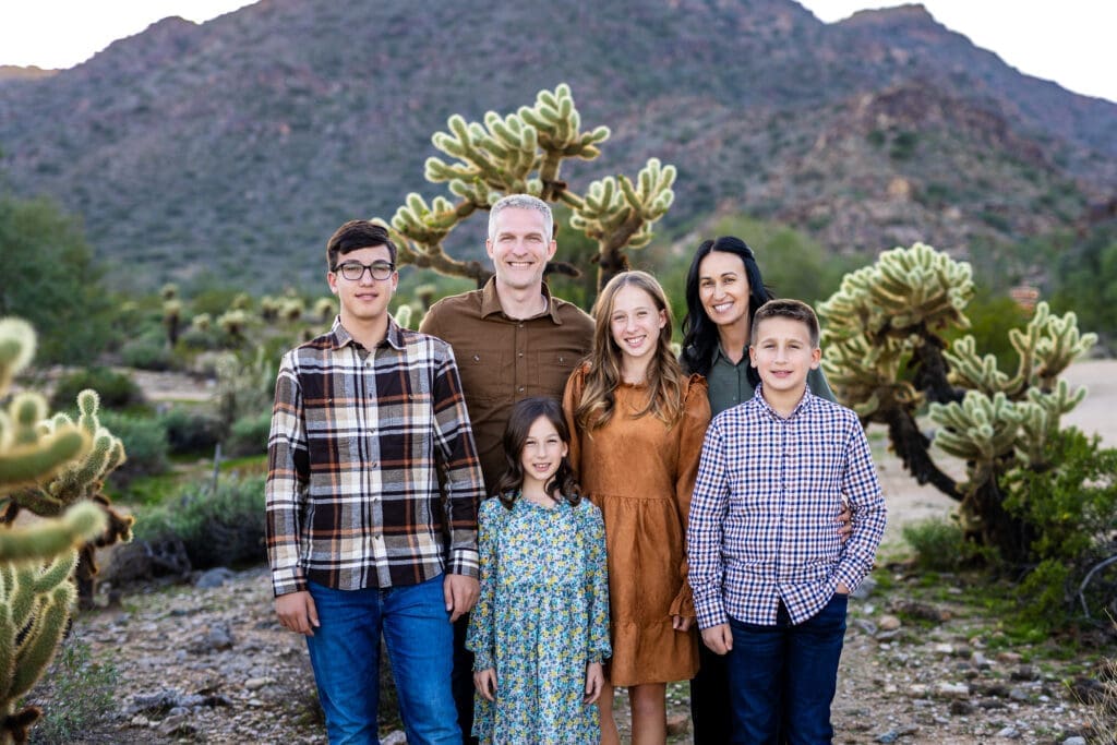 Family standing together in the desert during a photo session at White Tank Mountain Regional Park near Phoenix, Arizona.